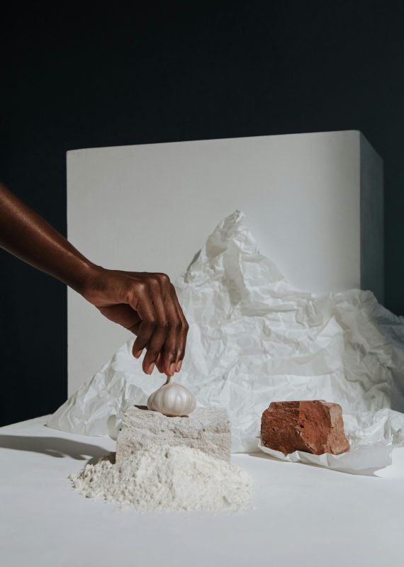 Creative arrangement of culinary ingredients with a garlic bulb, reflecting art in cooking.